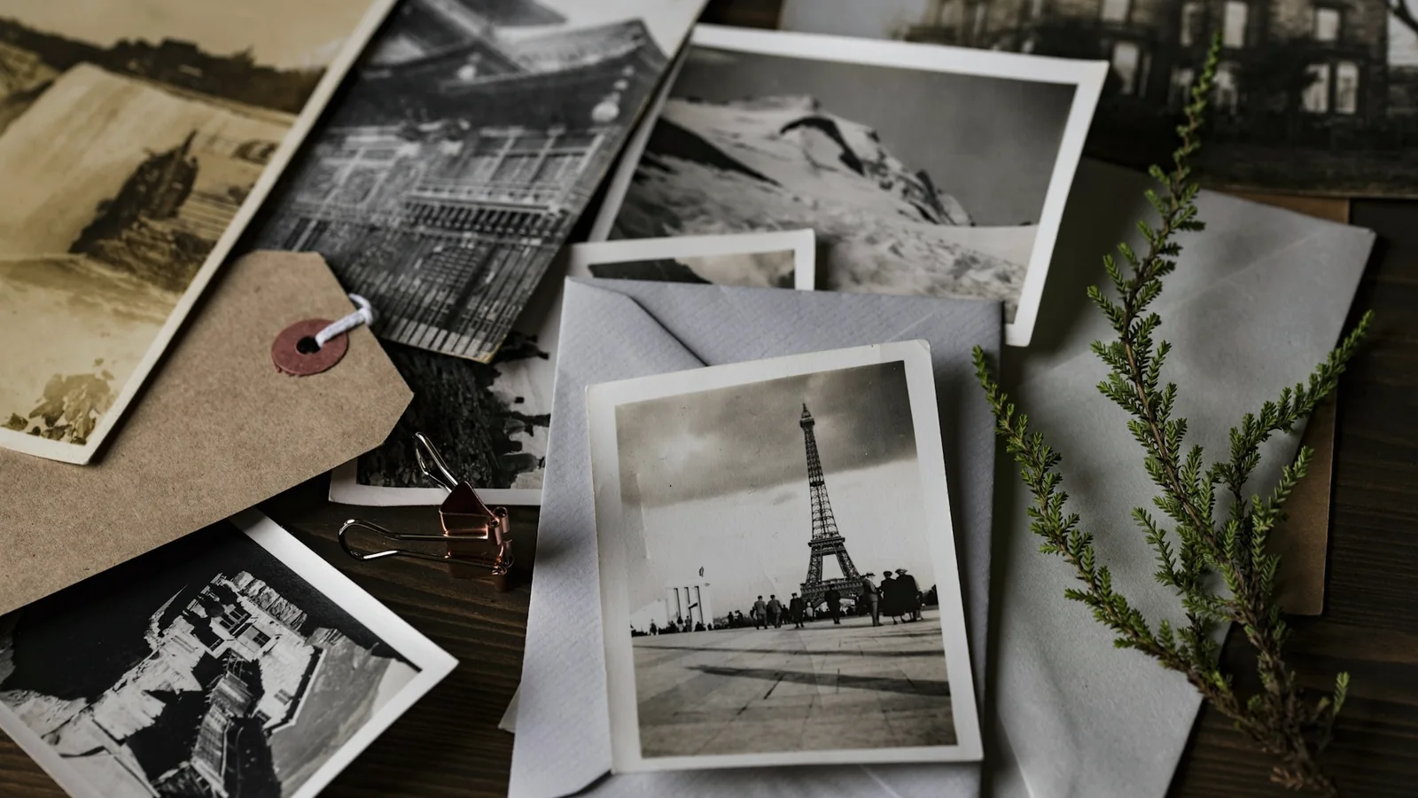 Cartes postales et photographies anciennes en noir et blanc éparpillées sur une table