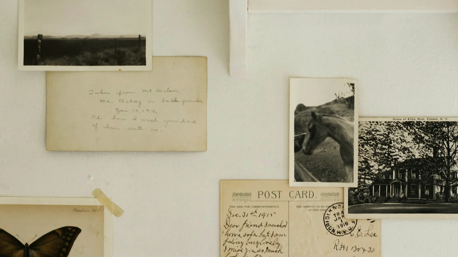 Cartes postales manuscrites et photographies anciennes fixées sur un mur clair