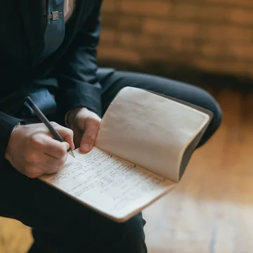 Mains qui notent dans un carnet pendant une séance