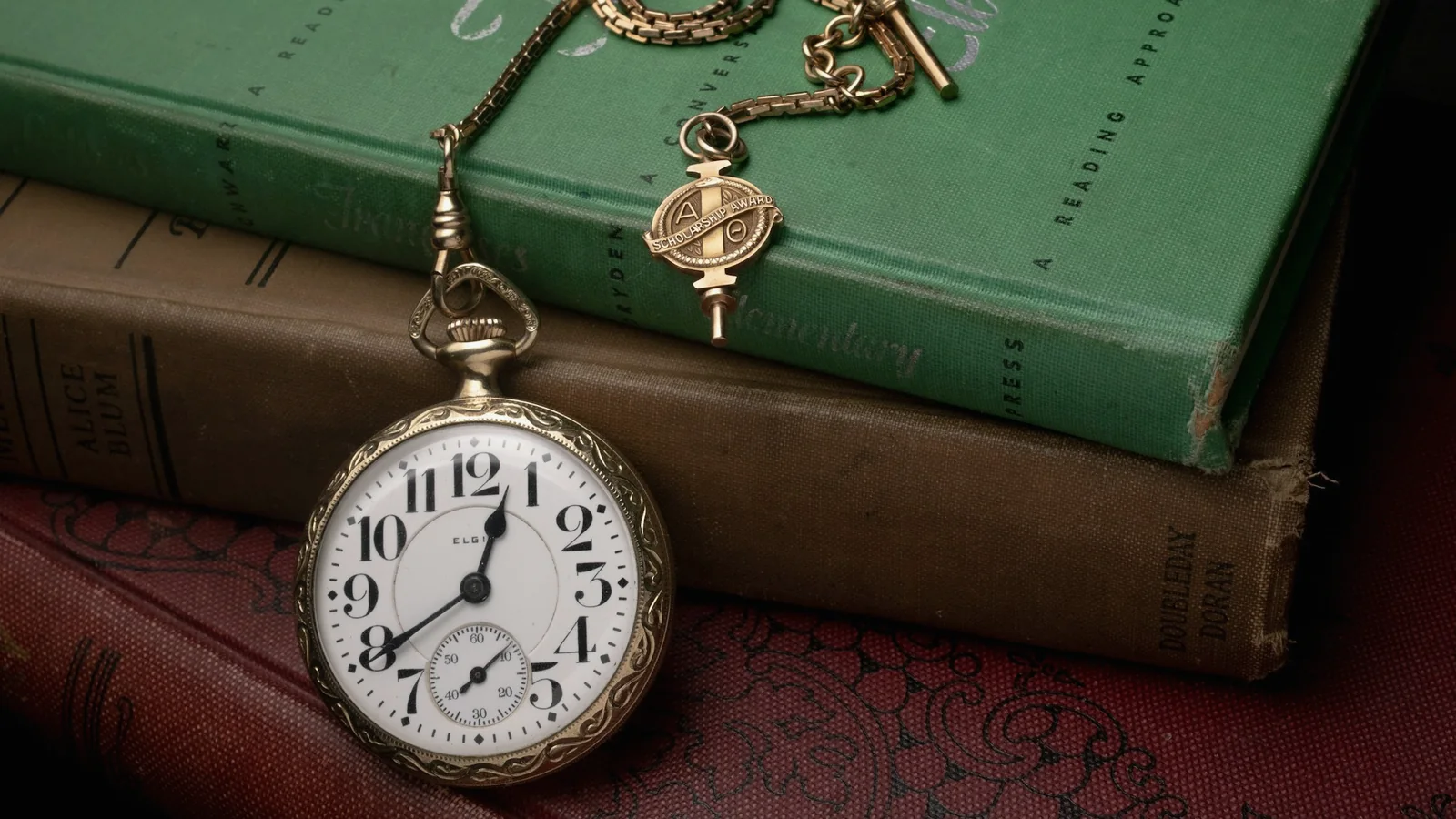 Montre à gousset ancienne posée sur une pile de livres reliés